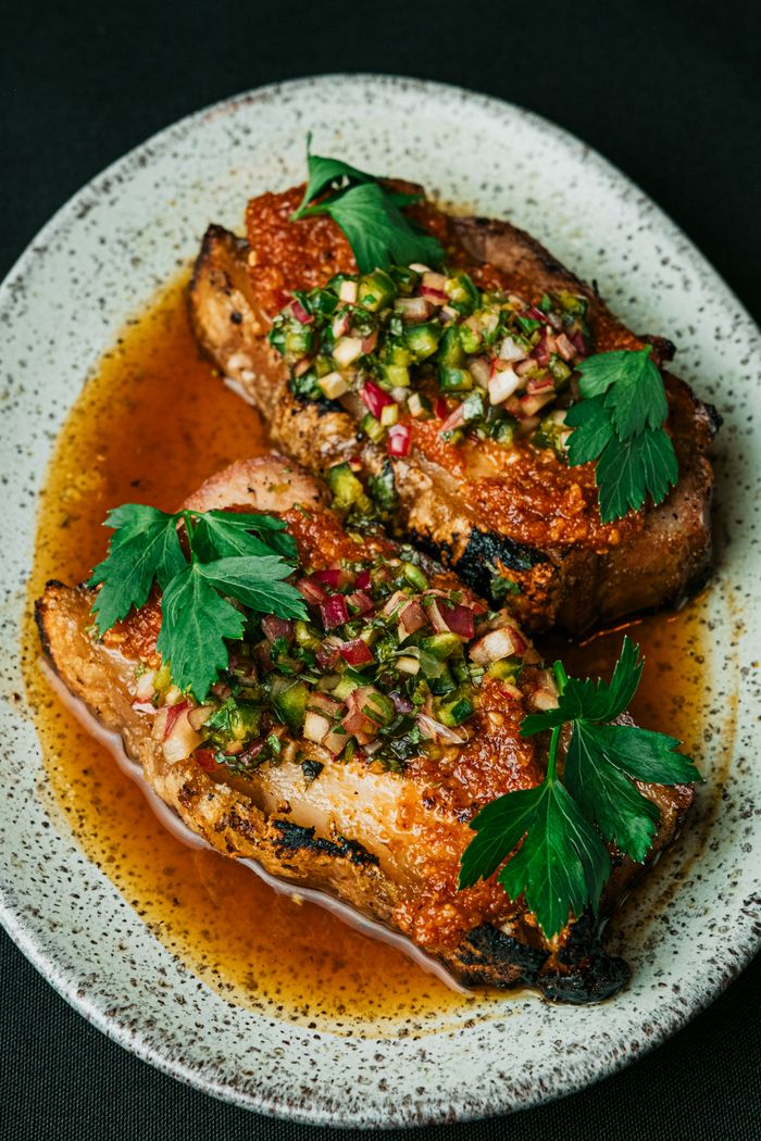 Deliciously seasoned pork chops garnished with herbs, served in a rustic setting.